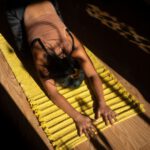 Restorative Yoga - woman in black tank top lying on yellow hammock