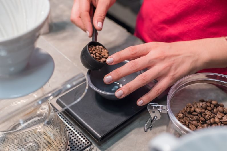 Food Scale - person scooping and measuring coffee beans