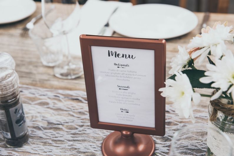 Restaurant Menu - Menu-printed board with brown frame on table