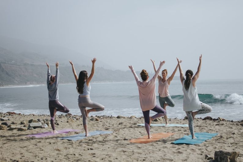 Yoga Teacher - five woman standing on seashore