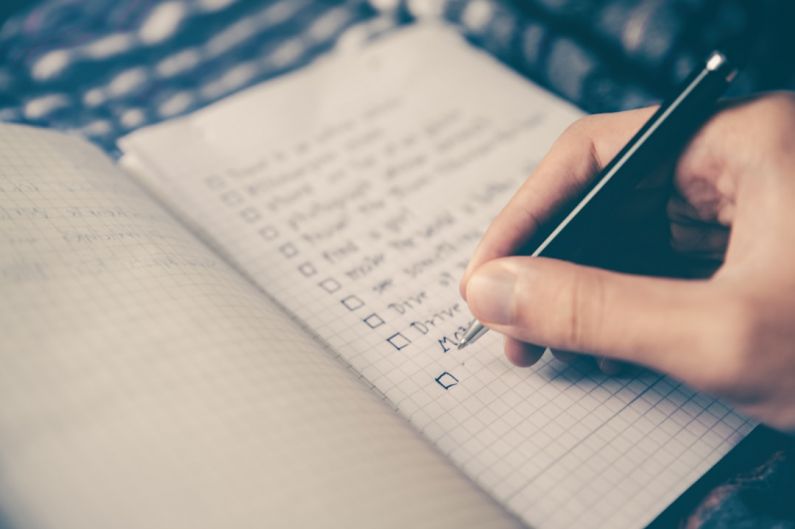 Workout Planning - person writing bucket list on book