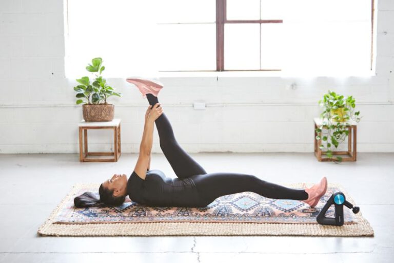 Yoga Recovery - woman in black tank top and black leggings lying on black and white floral area rug