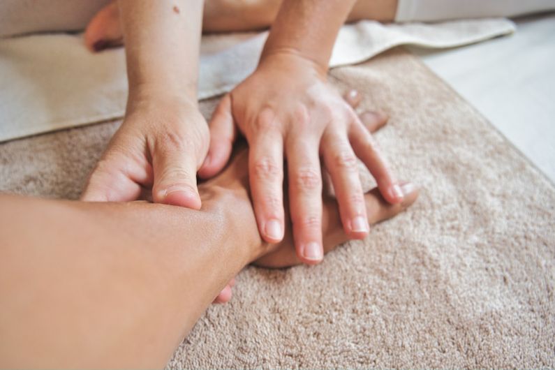 Massage Therapy - persons hand on persons lap